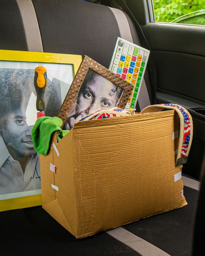 A cardboard box packed with framed photos and keepsakes