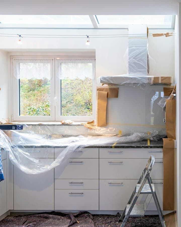 A kitchen being renovated, with cabinets wrapped and protected
